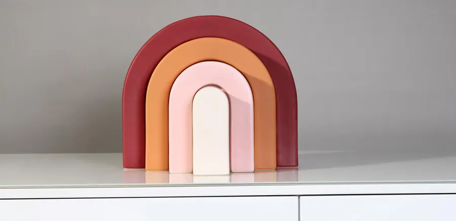 Nested rainbow-arch vases in red, orange, pink and cream